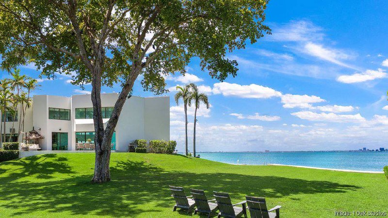 Miami waterfront estate with turquoise ocean views and manicured lawn