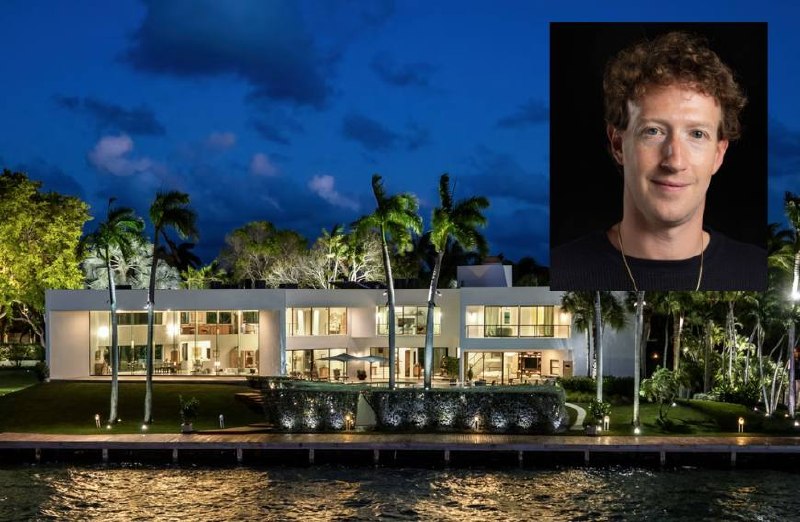 Contemporary waterfront mansion with landscape lighting at twilight