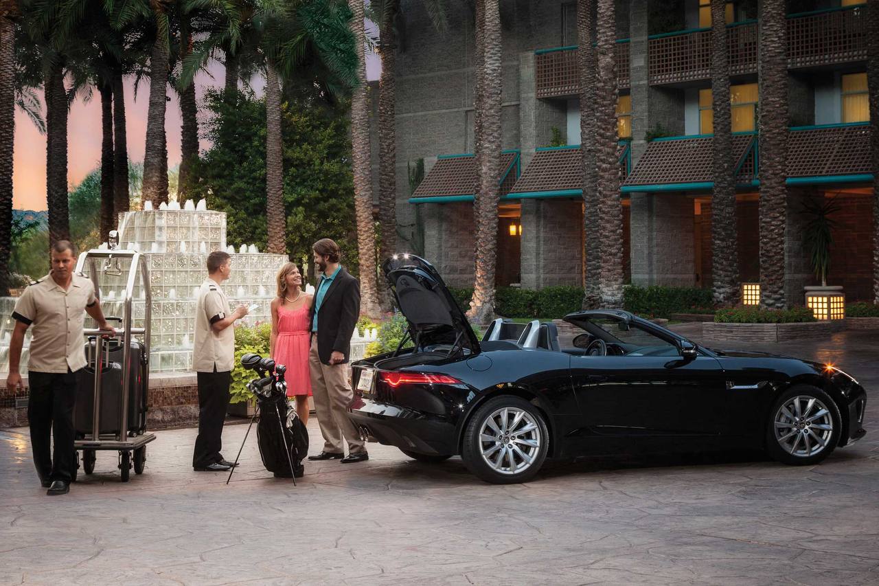 Luxury hotel courtyard with exotic car and guests